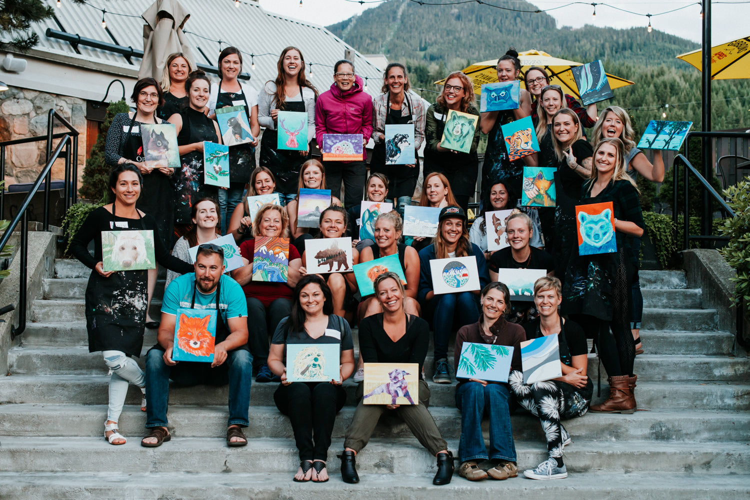 Group holding paintings after Paint Night with Whistler artist Andrea Mueller