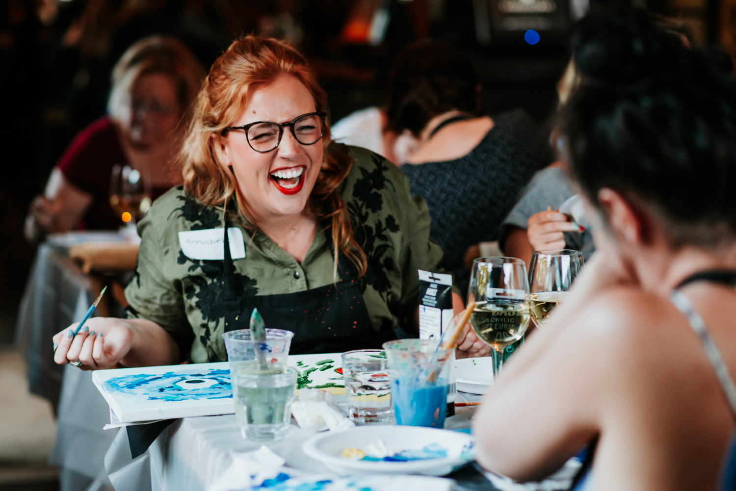 Lady laughing while painting at Whistler artist Andrea Mueller Paint Night