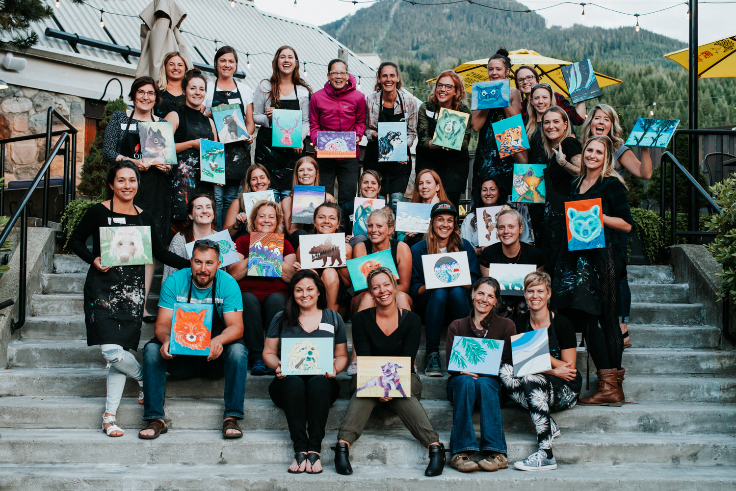 Group holding paintings after Paint Night with  Whistler artist Andrea Mueller